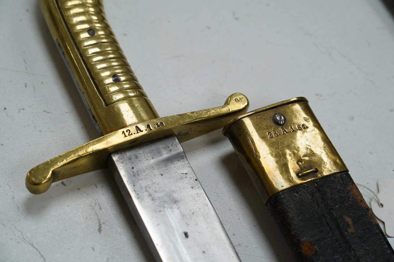 An 1855 Prussian infantry pioneer’s short sword, brass hilt stamped 12.A.1.10 in its brass mounted leather scabbard, blade 47.5cm. Condition - fair, some age wear